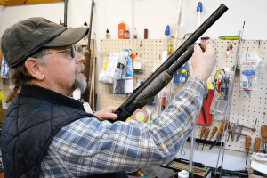 Bill Fairbrother works on a shotgun at his gun shop, Buck-N-Bears, in Mexico. Gunsmithing work makes up a small but significant part of the business, which Fairbrother runs with his wife and sons.