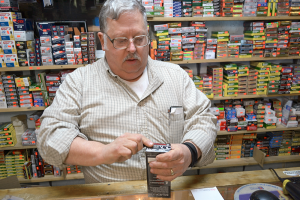 Skip Steinbrecher, owner of SharpShooters Gun Store in Richland, opens a box of ammunition. Small gun shops often stock hard-to-find firearms and ammunition that big box stores do not. 