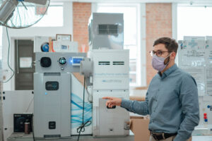 Christian Cobb, vice president of marketing, points out the equipment that produces air filtration systems at HealthWay.